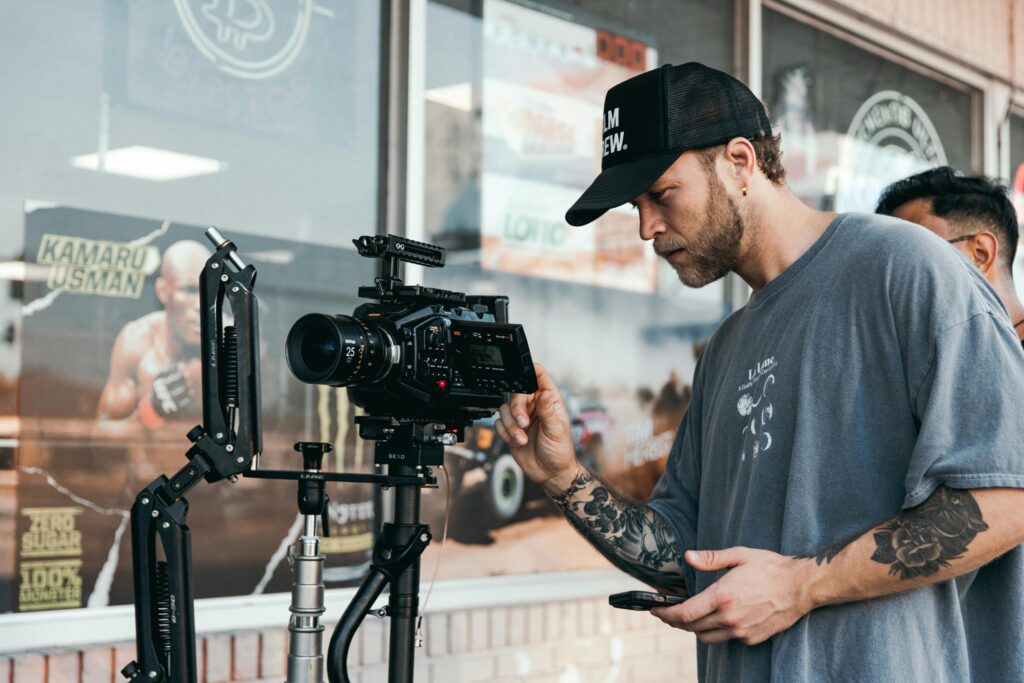 pexels-photo-18015232-18015232 A filmmaker in a casual setting adjusting a professional camera rig for shooting.